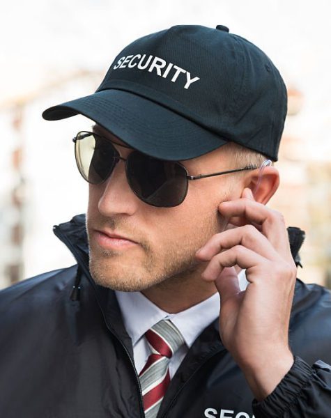 Portrait Of Young Male Security Guard Listening To Earpiece